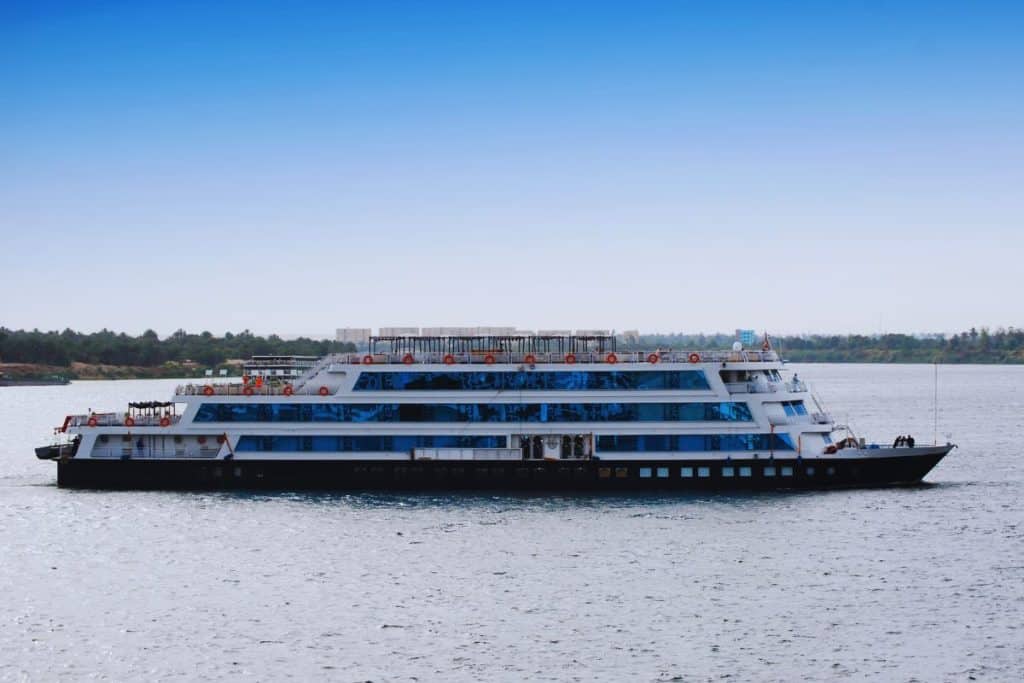 une-vue-panoramique-du-nil-avec-un-bateau-de-croisiere-naviguant-sur-ses-eaux-calmes-au-loin-on-peut-apercevoir-les-pyramides-majestueuses-du-caire-temoins-des-merveilles-de-legypte-ancienne-